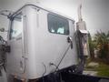 A silver 2013 International 5900i truck cab showing its side with a vertical exhaust pipe and a large window