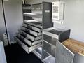 A 2017 Mercedes-Benz Sprinter interior featuring metal shelving units with multiple drawers and open compartments for storage