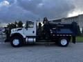 A 2011 International 7300 truck in white with a blue dump truck bed positioned for delivery or dumping activities