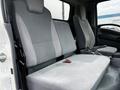 Interior view of a 2018 Isuzu NRR showing gray upholstered front seats with a bench seat design and armrests