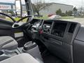 Interior view of a 2018 Isuzu NRR featuring a steering wheel dashboard gear shift and control panel