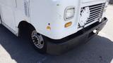 A white 2011 Ford Econoline with visible wear on the front bumper and a blank license plate holder