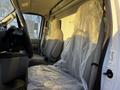 A 2017 Ford Econoline van with a driver's seat covered in plastic and gray upholstery visible inside the cabin