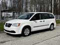A white 2011 Dodge Grand Caravan with sliding doors and a clean exterior parked on a concrete surface