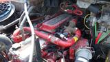 Close-up of the engine compartment of a 2017 Freightliner M2 106 featuring a prominently displayed red engine and various tubes and wires connected to components