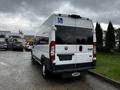 A white 2016 RAM Promaster van with a wheelchair accessibility sign on the rear and black tinted windows parked on a gravel surface