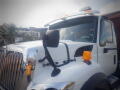 A 2016 International WorkStar 7500 truck with a shiny front grille large side mirror and an orange beacon light on top of the cab