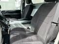 Interior view of a 2011 Dodge Grand Caravan showing front seats and center console with cup holders