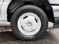 A close-up of a white tire on a 2022 Ford E-450 showcasing a silver rim and a black tire with visible tread patterns