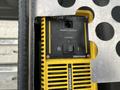 A yellow and black power inverter with remote output and status indicators mounted on a metallic surface