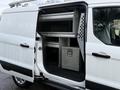 A 2017 Ford Transit Connect with an open side door revealing interior shelving and a metal storage compartment along the wall