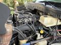 A 2011 International 4300 engine with various hoses and fluid reservoirs visible showcasing the mechanical components and design of the vehicle's engine system