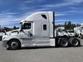A 2022 Freightliner Cascadia semi-truck in white with a streamlined cab and large wheels positioned in a parking area