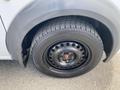 A close-up of a black steel wheel on a 2013 Ford Transit Connect featuring a tire with visible tread and lug nuts