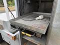 A stainless steel tray with a handle is partially pulled out from the compartment of a 2015 Ford F-350 SD truck