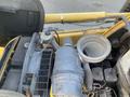 Close-up view of the engine compartment of a 2007 Komatsu WB156PS-5 showcasing various mechanical components including a turbocharger and air filter assembly