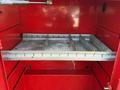A red tool storage compartment with metal shelves and dividers designed for organizing tools and equipment