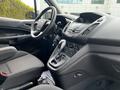 Interior view of a 2016 Ford Transit Connect showing the steering wheel gear shift console and front seats