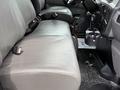 Interior seating and console of a 2022 International MV607 with gray fabric upholstery and seatbelts visible