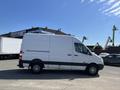 A white 2010 Mercedes-Benz Sprinter van seen from the side with black wheels and no windows on its cargo area