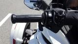 A close-up view of the handlebar and controls of a 2013 Can-Am Spyder showcasing the grip and various buttons