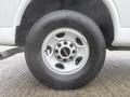 A close-up view of a silver wheel with a GMC logo and a black tire on a 2014 GMC Savana