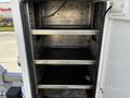 An interior view of a 2018 Ford F-550 featuring metal shelves inside a storage compartment