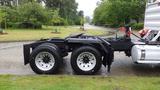 A 2019 Western Star Trucks 4900 SA with a black chassis and dual rear tires parked on a wet surface