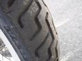 Close-up of a worn tire on a 2009 Harley-Davidson Flstc showing tread patterns and dirt on the surface