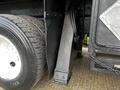 Close-up of a 2008 International 7500 truck showing a tire and part of the chassis with a mounted support structure and flexible hoses