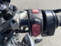 Close-up of the handlebar controls of a 2018 Triumph Street Triple RS featuring red buttons for hazard lights and traction control