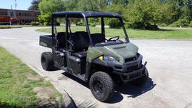 A 2016 Polaris Ranger 570 Crew all-terrain vehicle with a black and green exterior featuring a flatbed rear and seating for four with rugged tires