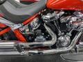 2024 Harley Davidson Fat Boy showcasing a glossy red paint job chrome engine and polished exhaust pipes