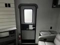 Interior view of a 2022 Aspen Trail trailer showing a closed door with a window and an exit sign above it