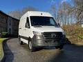 A 2021 Mercedes-Benz Sprinter van with a white exterior and dark front grille parked on a paved surface