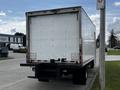 A white 2018 Hino 195 box truck with a blank rear door and black bumper parked on a street