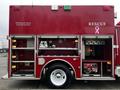 A red 1995 Freightliner FL70 fire truck with the word RESCUE displayed on the side and compartments for equipment and tools