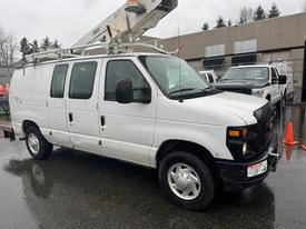 A 2008 Ford Econoline van with a white exterior and a utility bucket attached to the roof