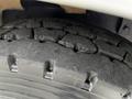 Close-up of a worn tire from a 2015 Spartan School Bus showing visible tread patterns and cracks on the surface