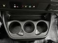 A black molded plastic console with three cup holders and control buttons for various vehicle functions