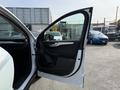 A 2020 Ford Escape with the front door open showcasing the interior features and door panel design
