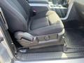 A black cloth seat in a 2014 Ford F-150 with a foldable armrest and console features