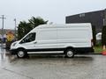 A white 2023 Ford Transit van is parked with a tall body and large cargo space visible on the side