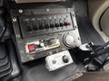 The interior control panel of a 2008 Ford F-450 featuring switches for lights and a throttle control with worn surfaces and various buttons