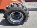 A close-up view of a large, rugged tire on a 2008 JLG Boom Lift featuring deep treads for traction and a central metal hub