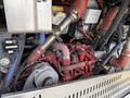 A close-up view of the engine compartment of a 2018 Grande West Vicinity showing red and silver engine components and various hoses and wires