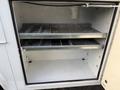 A white 2018 Ford F-350 with an open storage compartment featuring metal shelves for organization