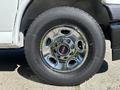A chrome wheel from a 2019 GMC Savana featuring five circular holes and a black GMC logo in the center with a thick black tire attached