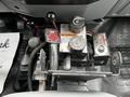A control panel with various knobs levers and switches including a warning sign in a 2011 Ford F-550 vehicle interior