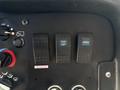 Control panel of a 2019 Freightliner MT45 with three switches labeled for dome lamp and cargo functions along with a cab unlock button and various dials and buttons